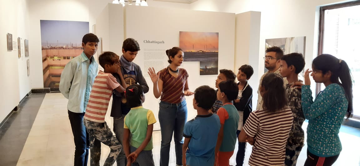 Children standing in circle at art exhibit