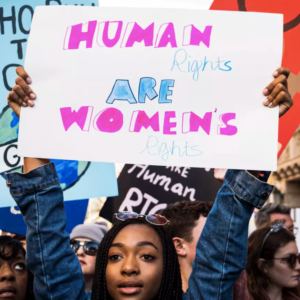 woman holding sign that says human rights are womens rights