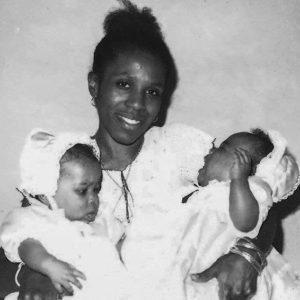 Black and white photo of woman holding two babies