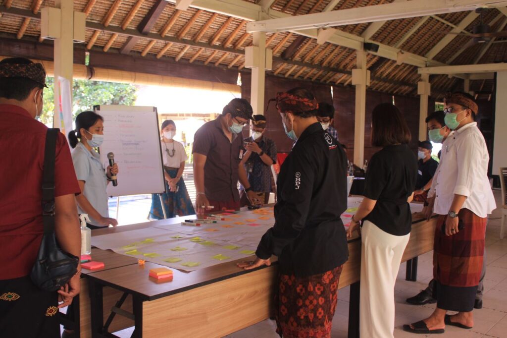 People gathered around a table analyzing Bali's EV landscape